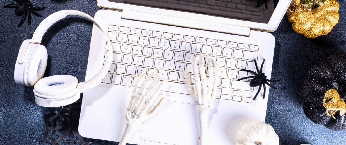 spooky image of skeleton hands typing on a computer